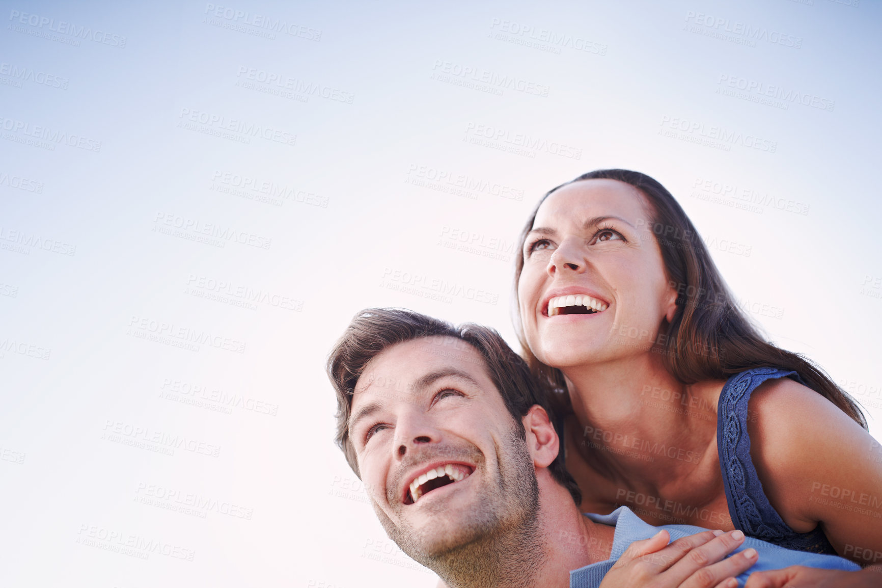 Buy stock photo A handsome man piggybacking his loving wife outdoors