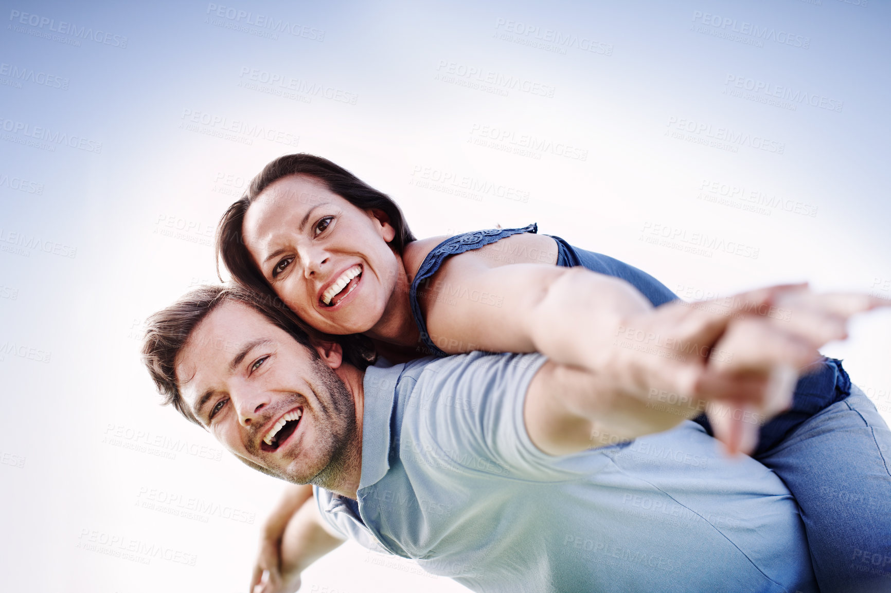 Buy stock photo A handsome man piggybacking his loving wife outdoors