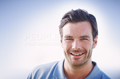 Buy stock photo Head and shoulders shot of a handsome young man smiling while standing outside