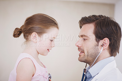 Buy stock photo A little girl having her annual medical checkup done by a male doctor