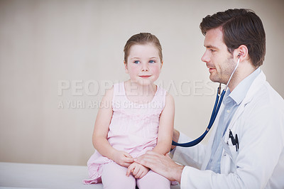 Buy stock photo A male doctor doing a general medical examination of a little girl with his stethoscope