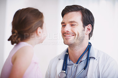 Buy stock photo Shot of a friendly male doctor smiling at his young patient