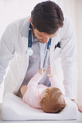 Buy stock photo A male doctor standing by an infant patient