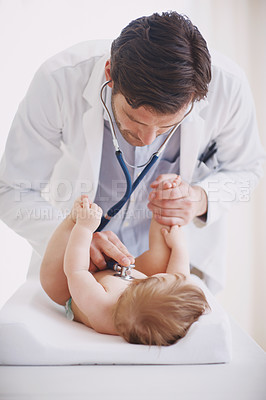 Buy stock photo A male doctor examining an infant girl with his stethoscope