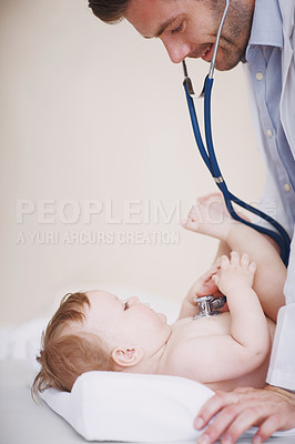 Buy stock photo Cropped shot of a male doctor examining an infant girl