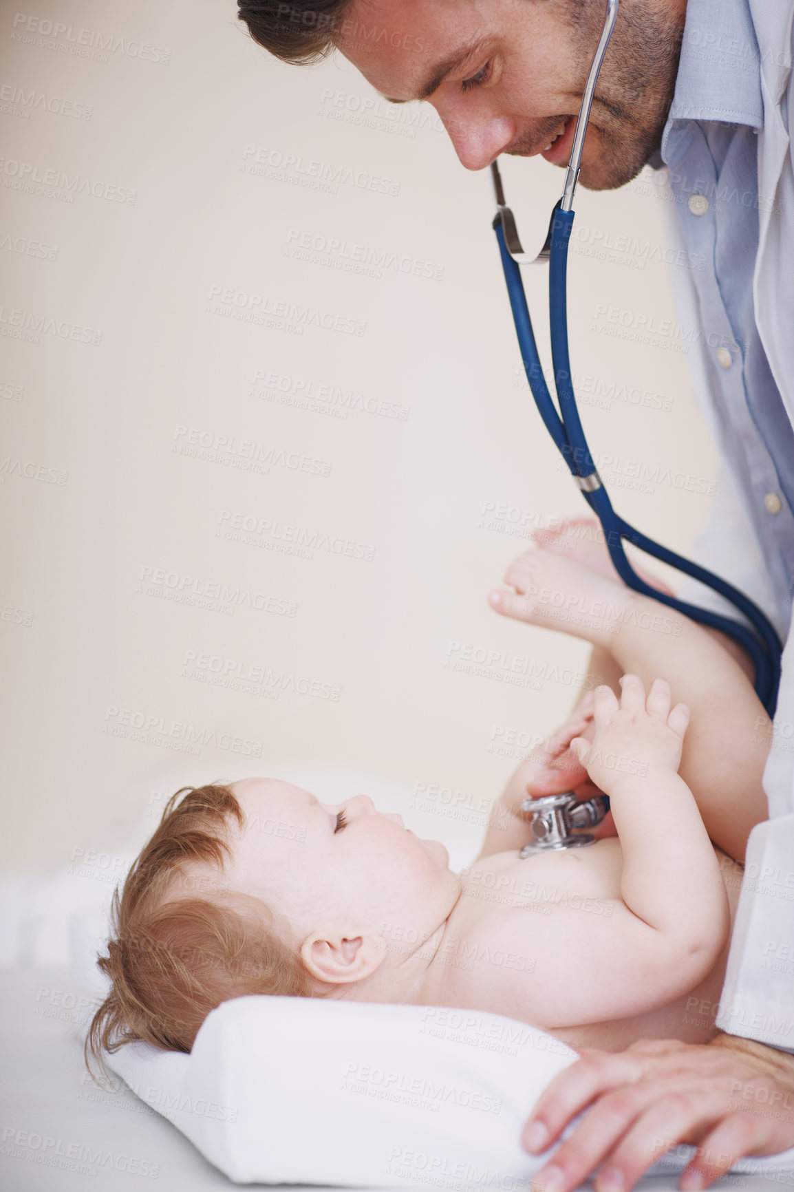Buy stock photo Cropped shot of a male doctor examining an infant girl