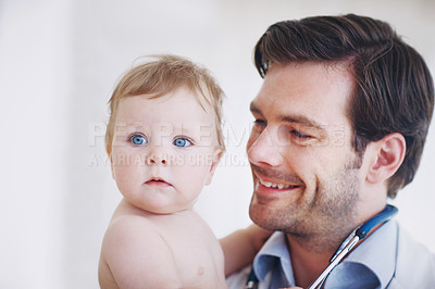 Buy stock photo Closeup shot of a young male doctor holding an infant girl in his arms