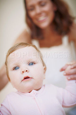 Buy stock photo Closeup shot of a baby girl being helped to by her mom to take her first steps