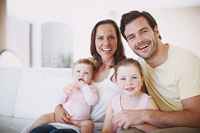 Buy stock photo Portrait of a happy family of four sitting together in their living room