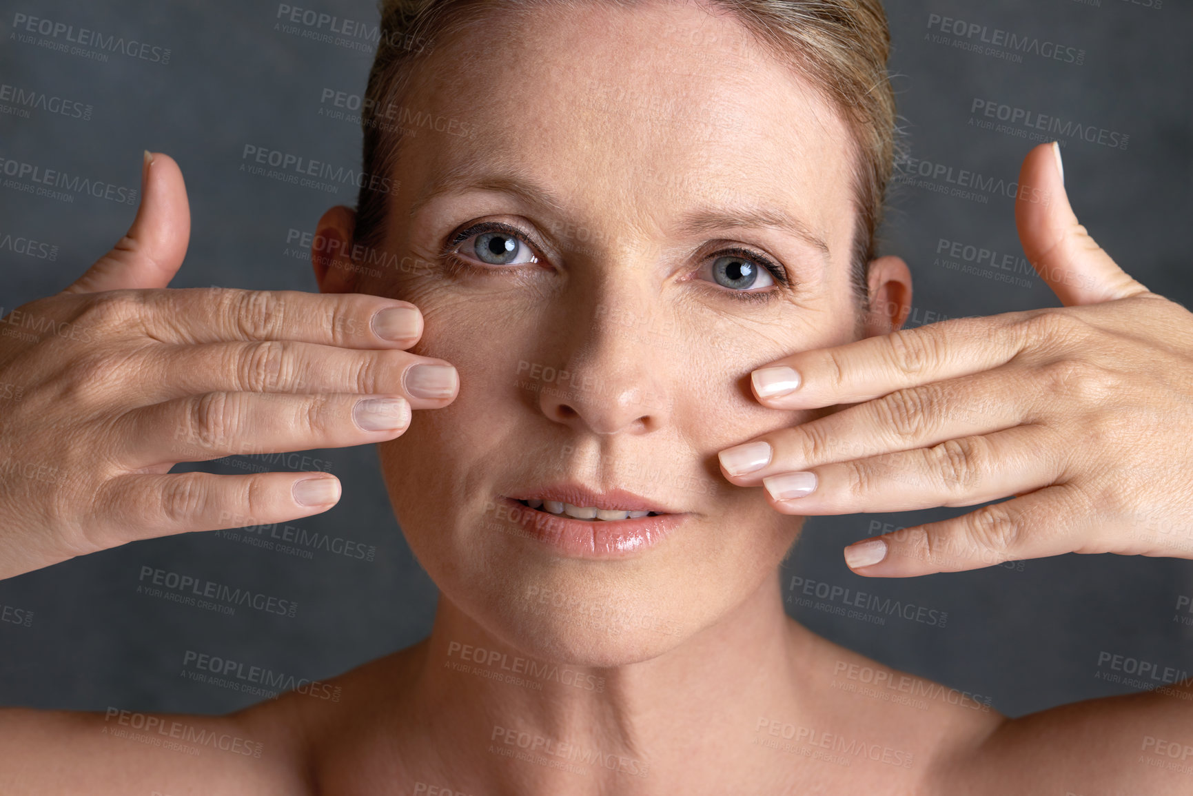 Buy stock photo Portrait, beauty and hands with mature woman in studio on gray background for aesthetic wellness. Face, relax and touching with natural skin person at spa for antiaging cosmetics or treatment
