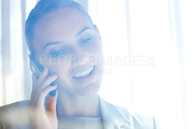 Buy stock photo View of a young business woman speaking on cellphone through a glass