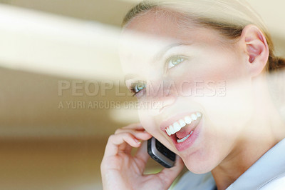 Buy stock photo View through a glass - Happy young female speaking on the cellphone