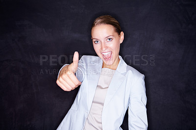 Buy stock photo Excited young business woman gesturing a thumbs up sign isolated a black background