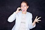Young angry business woman shouting over the phone