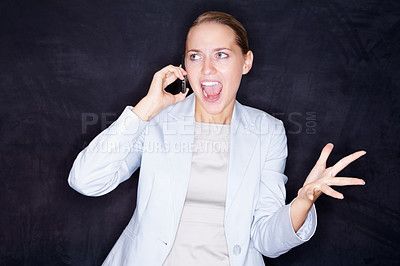Buy stock photo Aggressive young business woman shouting over a cellphone conversation , isolated on black