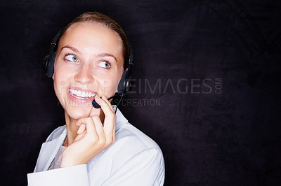 Buy stock photo Smiling young business woman with a headset isolated against black background