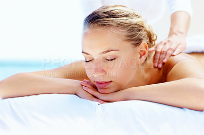 Young calm female receiving a shoulder massage at health spa