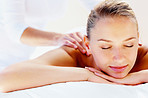 Serene woman receiving a shoulder massage at day spa