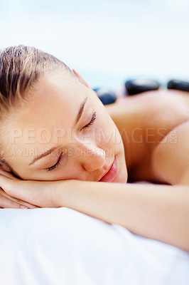 Buy stock photo Hot stone, massage and relax woman at a spa for wellness treatment and detox. Calm, muscle healing recovery and a female person with sleep at a resort or hotel with beauty therapist with skincare