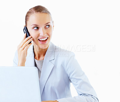 Buy stock photo Smiling young business woman using a cellphone and a laptop against white background