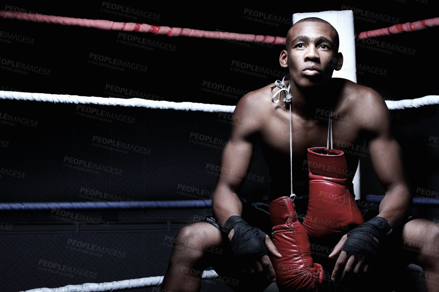 Buy stock photo Handsome African American boxer sitting with boxing gloves hanging on neck