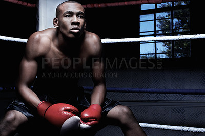Buy stock photo African American male athletic sitting in ring wearing gloves