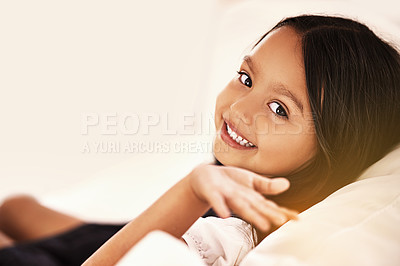 Buy stock photo Happy, relax and portrait of child on couch for playful, fun and resting on weekend in living room. Smile, childhood and face of young girl alone on sofa for vacation, holiday and free time in home