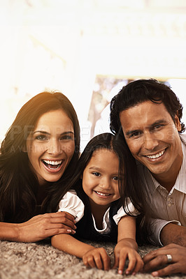 Buy stock photo Happy family, portrait and hug with support for love, bonding or relax together at home. Face of mother, father and little girl, child or young kid with smile for embrace, holiday or weekend on floor