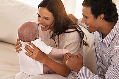 Buy stock photo Happy, family and parents with baby on sofa in home for bonding, relax together and relationship. Smile, morning and father, mother and newborn kid for care, love and child development in living room