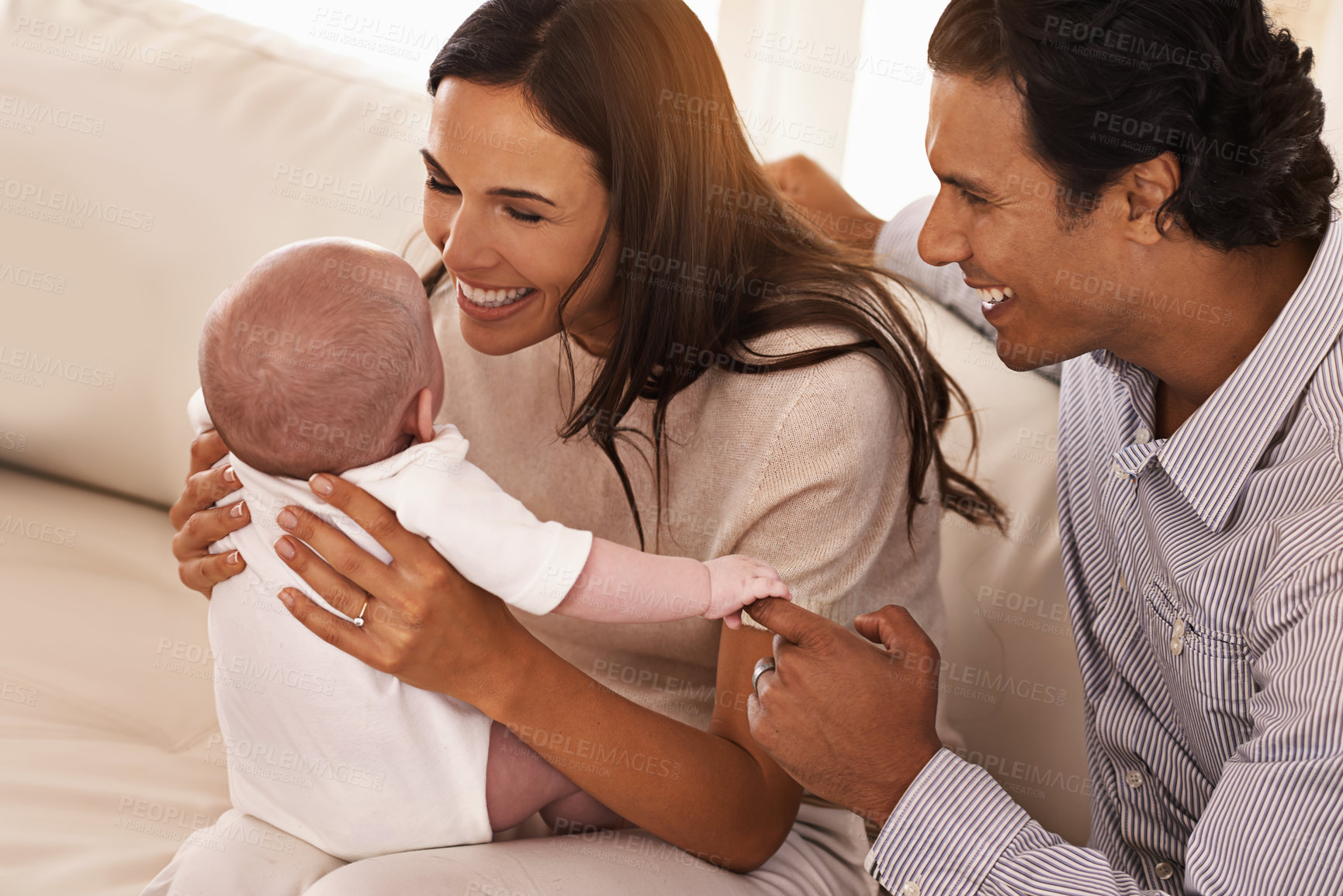 Buy stock photo Happy, family and parents with baby on sofa in home for bonding, relax together and relationship. Smile, morning and father, mother and newborn kid for care, love and child development in living room
