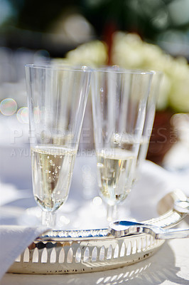 Buy stock photo Cropped shot of two champagne glasses standing on a table at a wedding reception