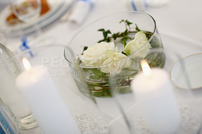 Buy stock photo Wedding reception decoration on a table with candles and glass. Decor with white flowers, roses, or plants for an event party. Dining table decoration, setting or setup for a summer celebration  