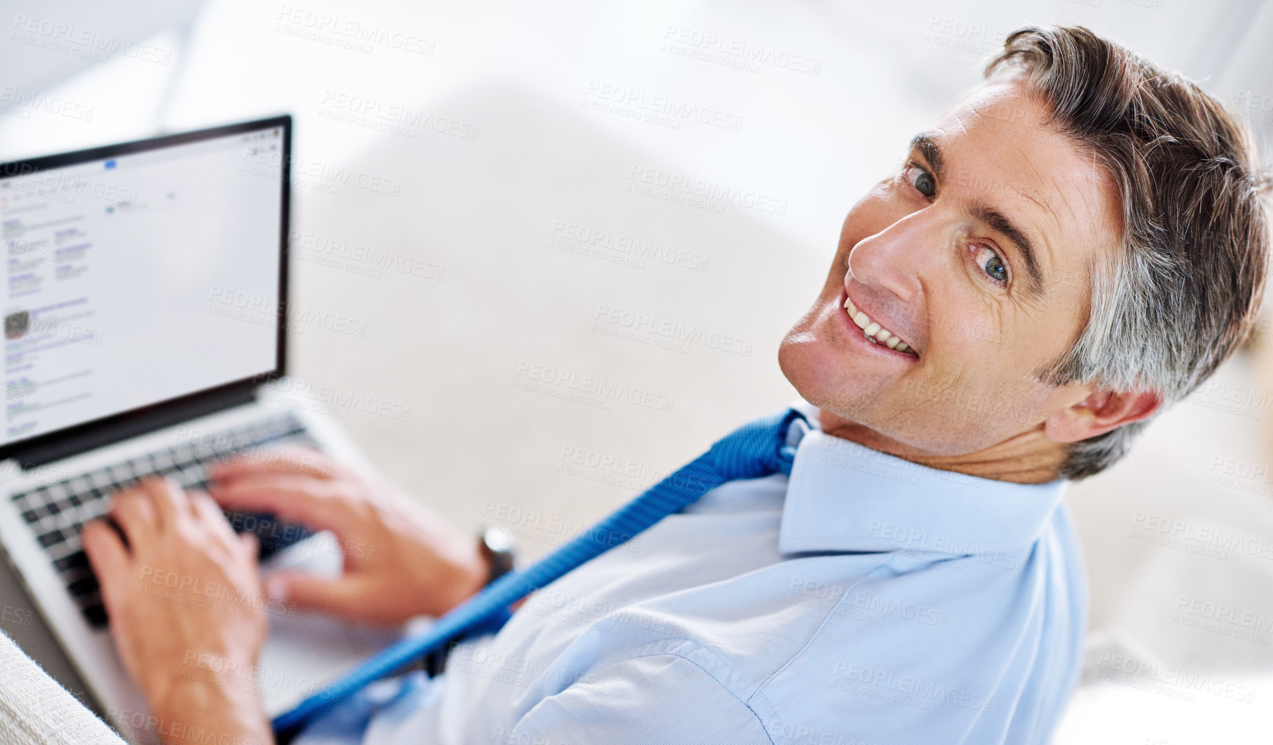 Buy stock photo Portrait of a mature businessman using a laptop while sitting on a sofa
