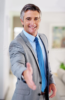 Buy stock photo Portrait of a smiling mature businessman extending his arm to shake hands