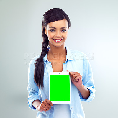 Buy stock photo Shot of a young woman presenting a digital tablet over a grey background