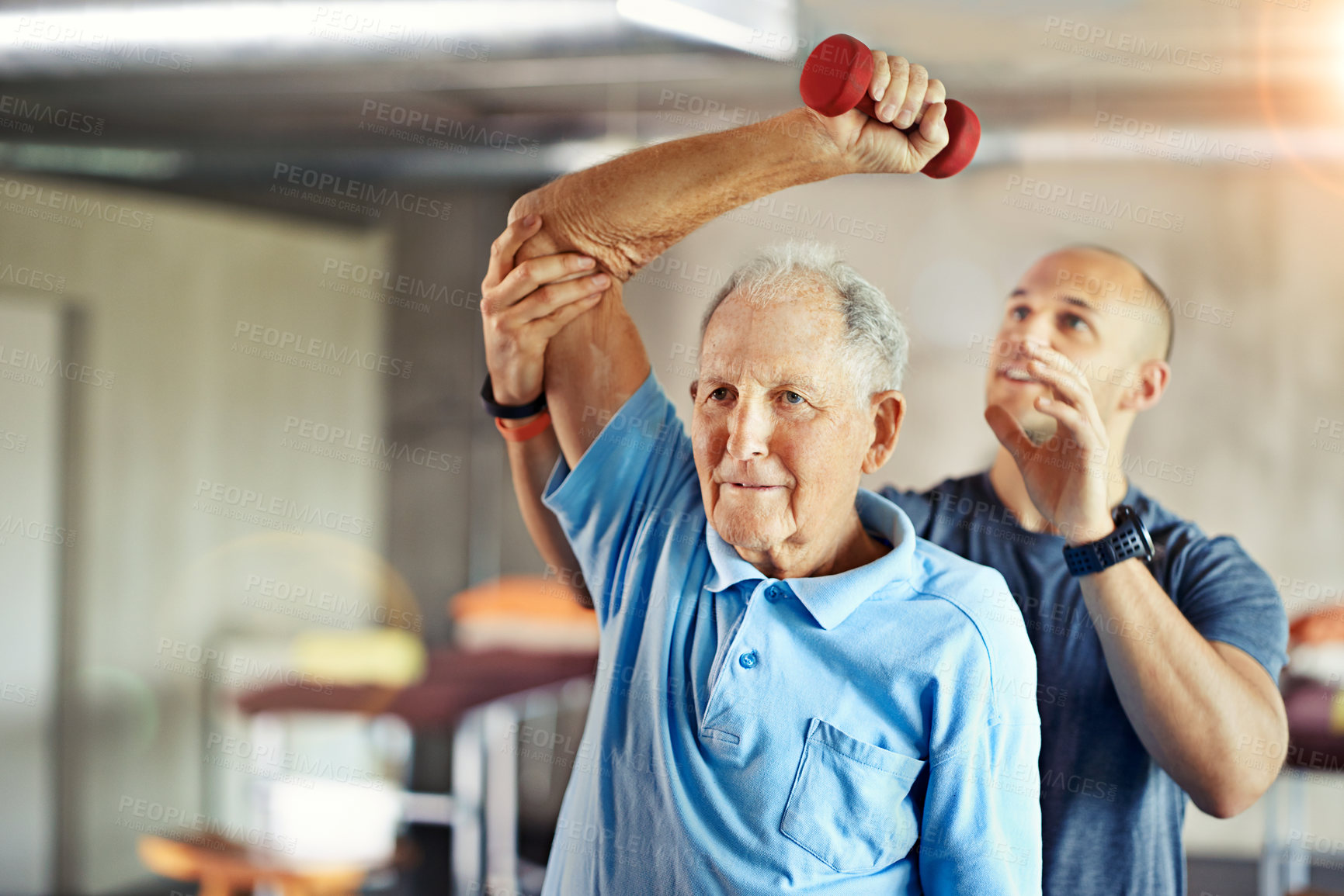 Buy stock photo Shot of a senior man working out with the help of a trainer