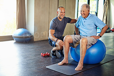 Buy stock photo Physiotherapist, helping and senior man with yoga ball, training and elderly support for care. Men, gym and exercise for health, wellness and coaching with dumbbell for mature rehab and wellbeing