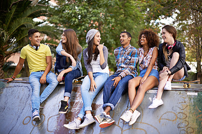 Buy stock photo Conversation, happy and group of friends at skatepark in city for bonding, talking and sitting together. Smile, diversity and young teenagers in conversation with skateboard in town for practice.