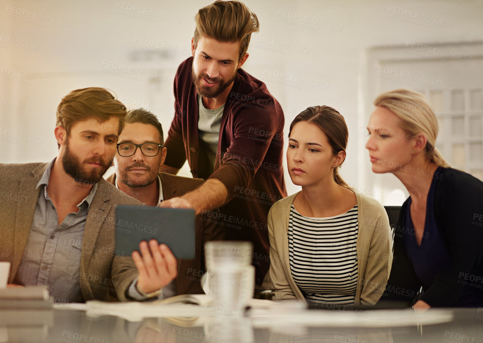 Buy stock photo Cropped shot of a group of businesspeople looking at a tablet in the boardroom