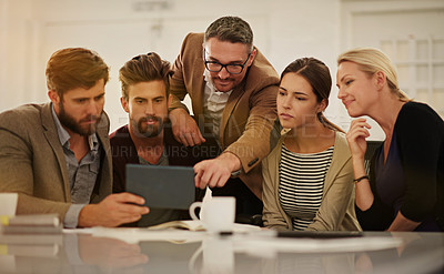 Buy stock photo Cropped shot of a group of businesspeople looking at a tablet in the boardroom