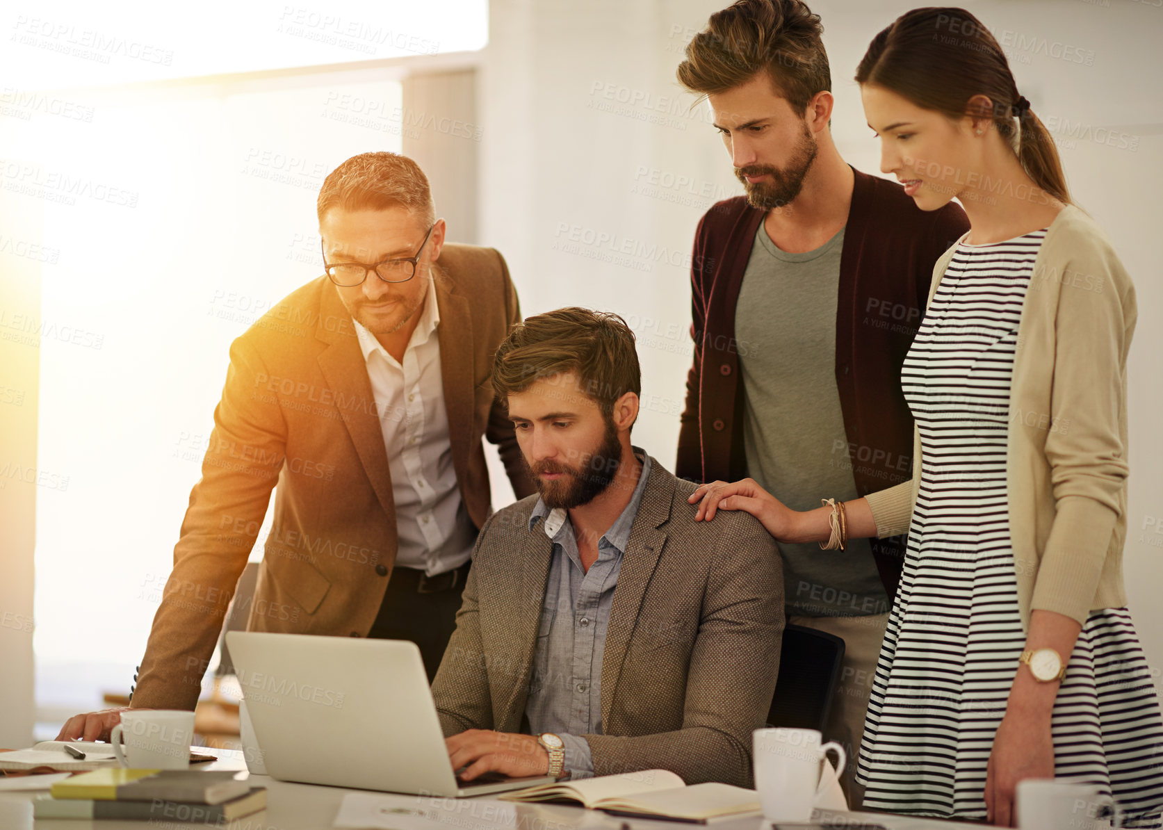 Buy stock photo Cropped shot of a group of businesspeople looking at a laptop in the boardroom