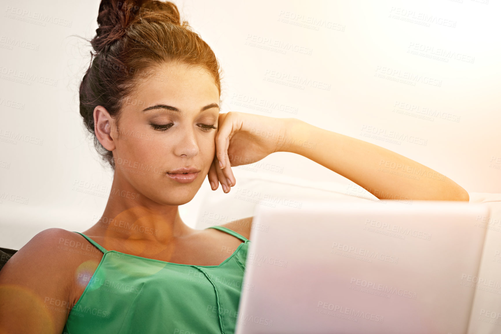 Buy stock photo Woman, think and relax on sofa with laptop for browse, social media and research for indoor or home on weekend. Student or scholar and alone with internet or web for read and thought with lens flare