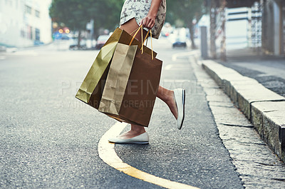 Buy stock photo Cropped shot of a woman with shopping bags crossing a city street