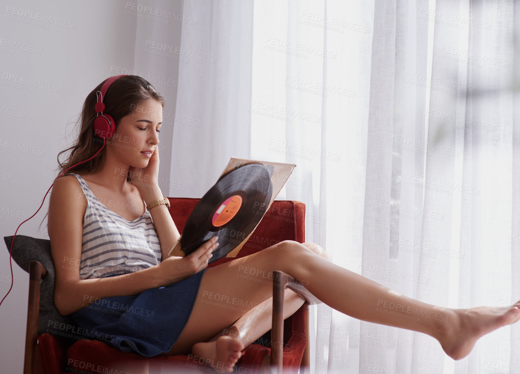 Buy stock photo Shot of a young woman listening to music while relaxing at home