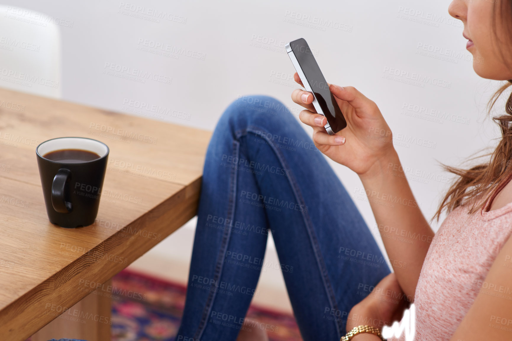 Buy stock photo Shot of a young woman using a cellphone at home