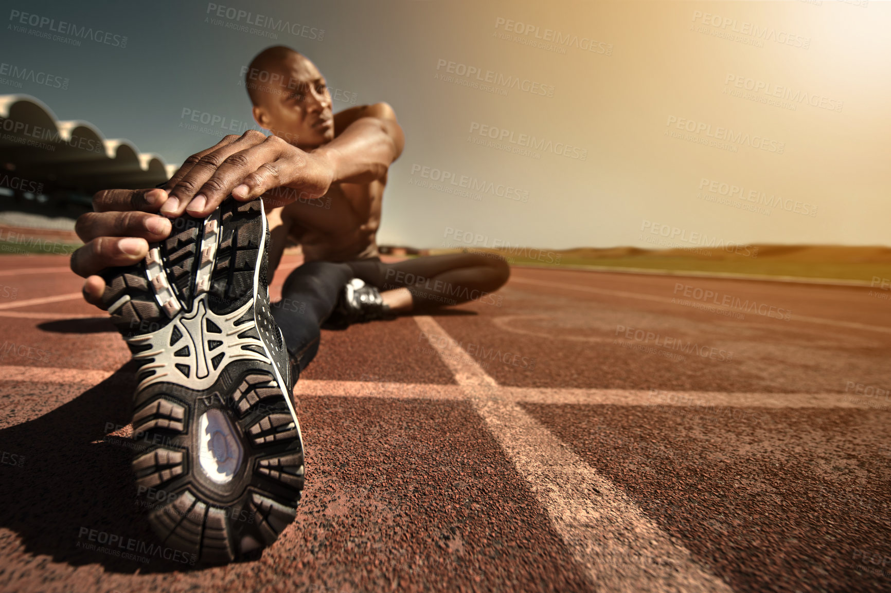Buy stock photo Man, shoes and stretching leg on ground, sunset and fitness for health, sports and performance. Black male person, athlete and warmup on track, workout and commitment or ready, train and outdoors