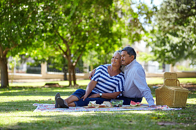 Buy stock photo Shot of a loving senior couple enjoying a leisurely picnic in the park