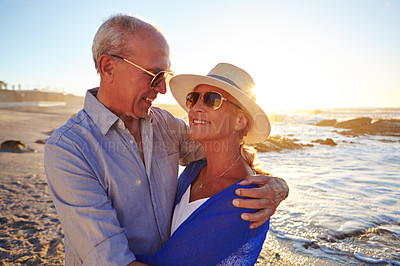 Buy stock photo Shot of an affectionate senior couple walking on the beach