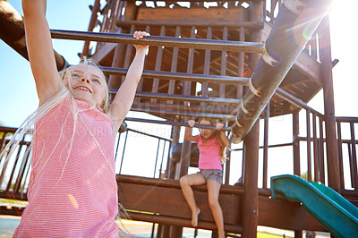 Buy stock photo Shot of two little girls playing on a jungle gym