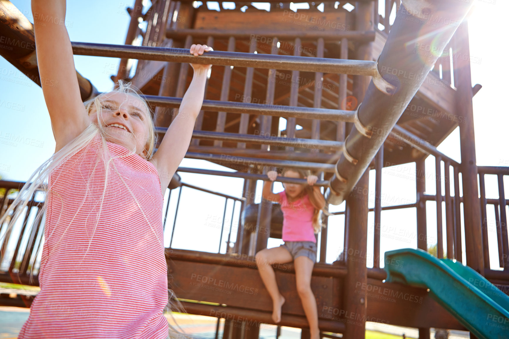 Buy stock photo Shot of two little girls playing on a jungle gym